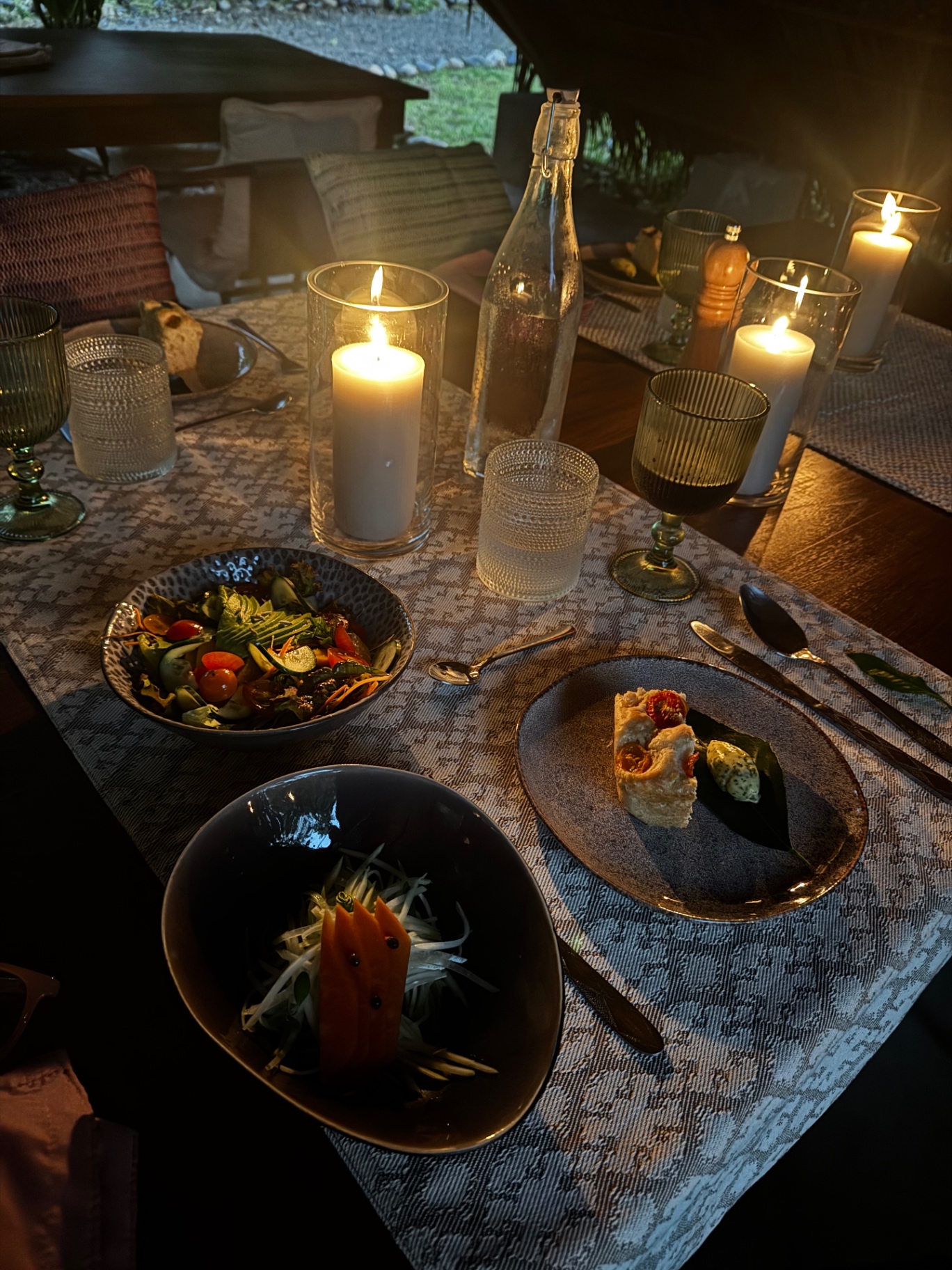 Shared table set with salads and candlelight